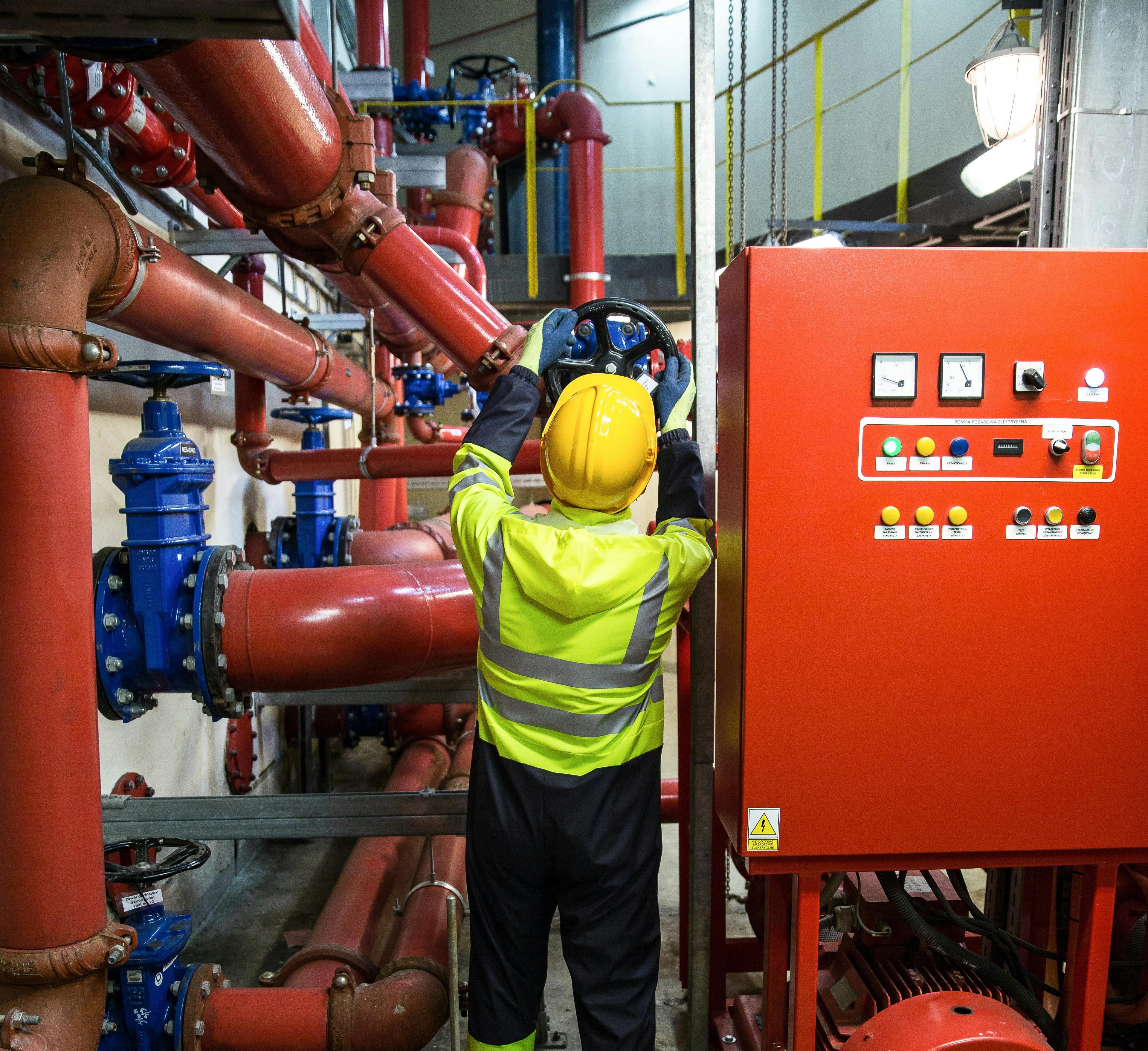 Industrial maintenance technician working on pipe systems